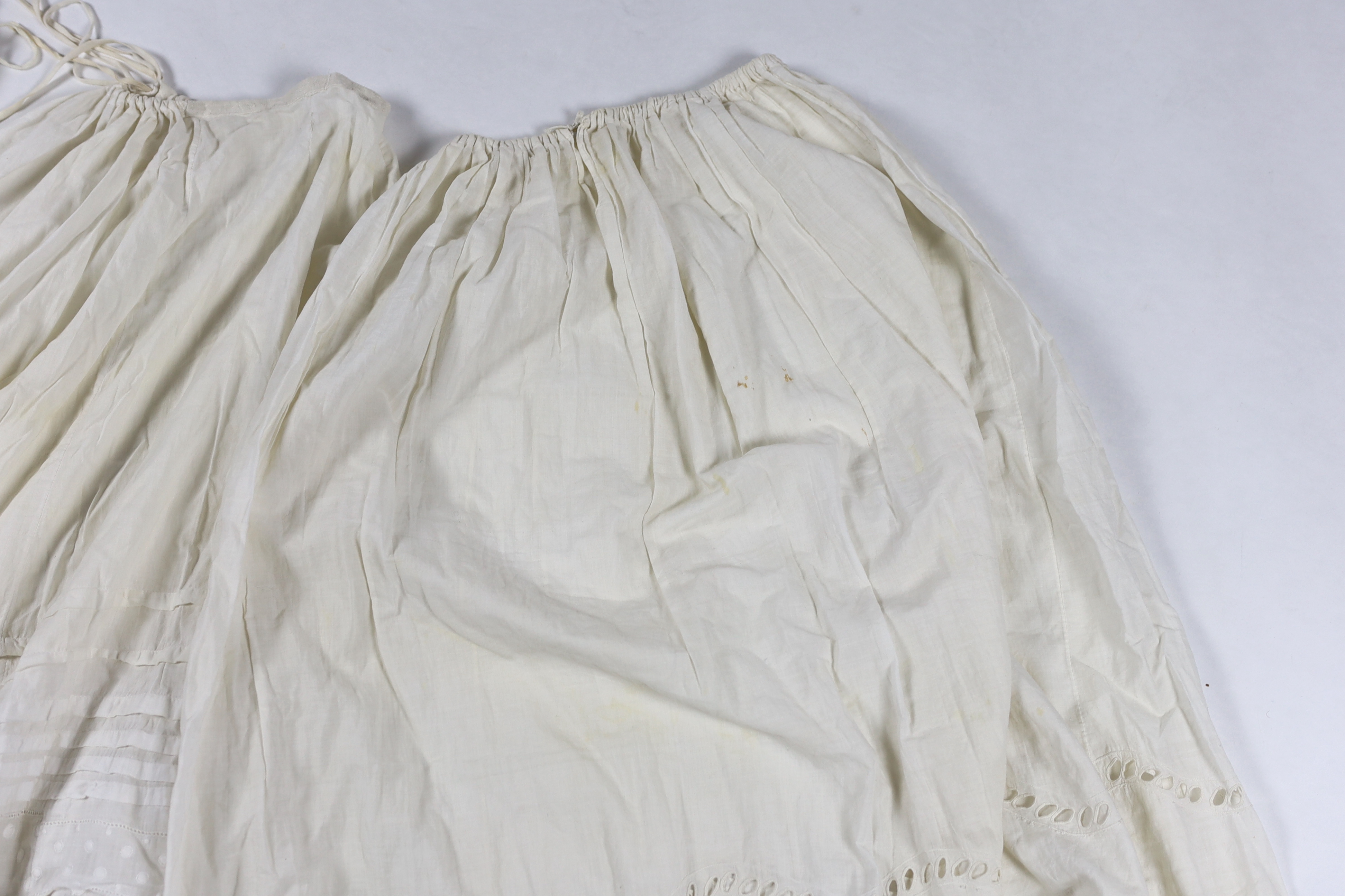 Three Victorian white worked petticoats; one two tiered, one lace trimmed with ribboning, the third worked with cutwork border, all approx. 94cm long